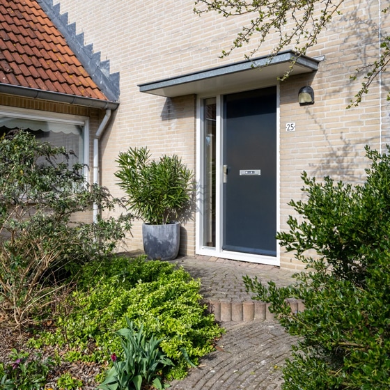 Voordeur van woning omringd met groen